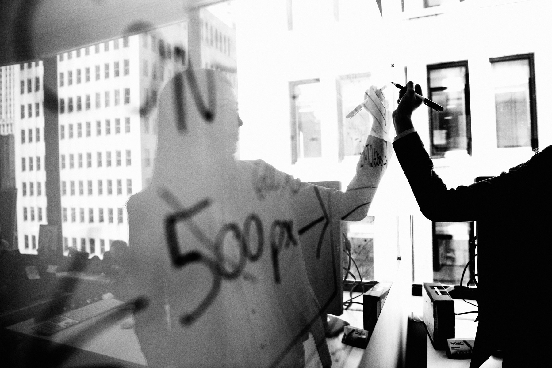 Practitioner mapping a plan on a glass wall